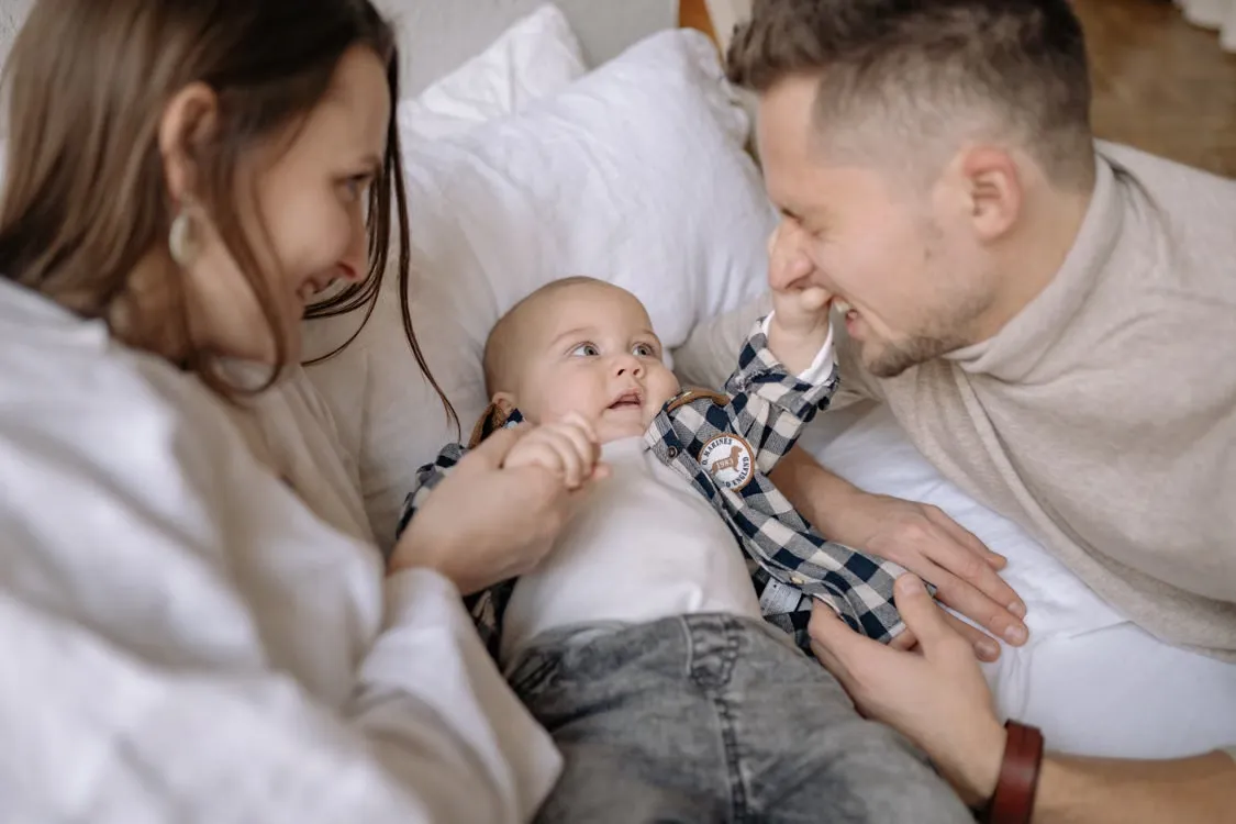 Parents laughing and spending quality time with their baby.