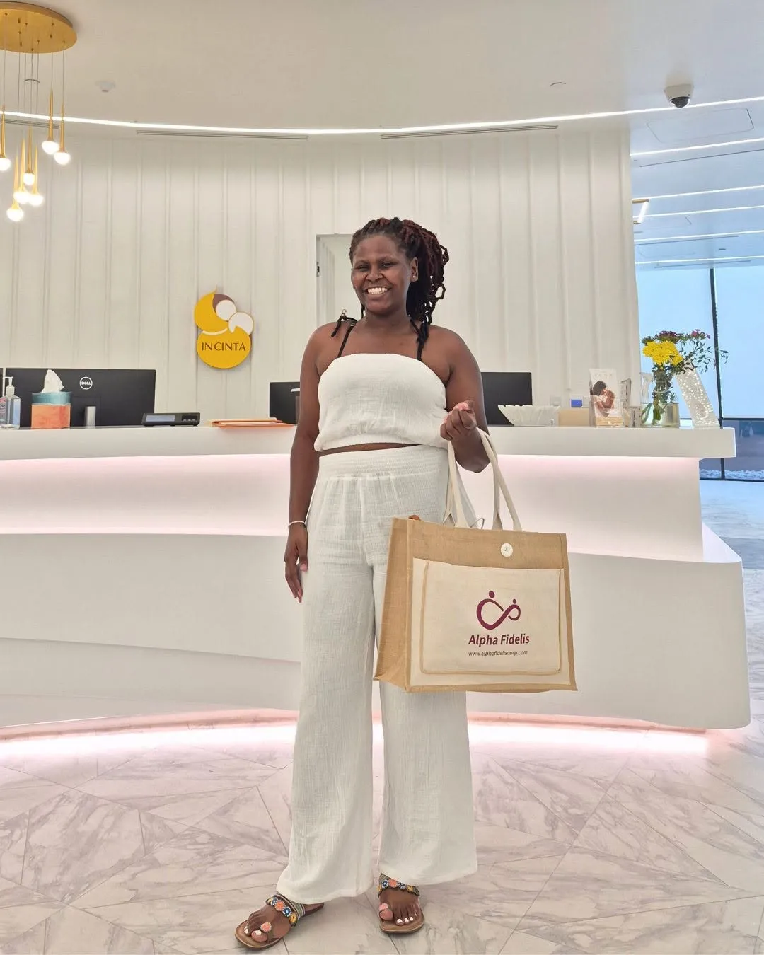 Smiling surrogate holding an Alpha Fidelis welcome bag.